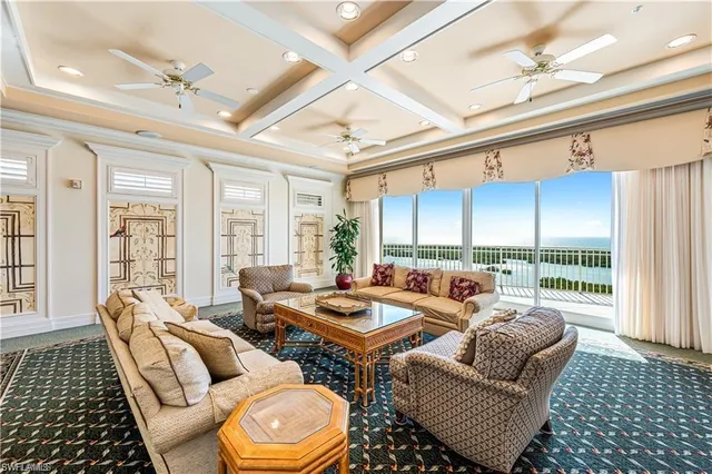 a living room with furniture and a floor to ceiling window