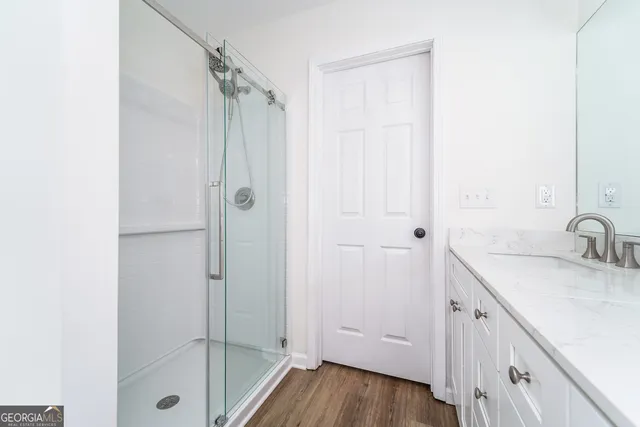 a bathroom with a granite countertop sink a mirror a shower and a bathtub