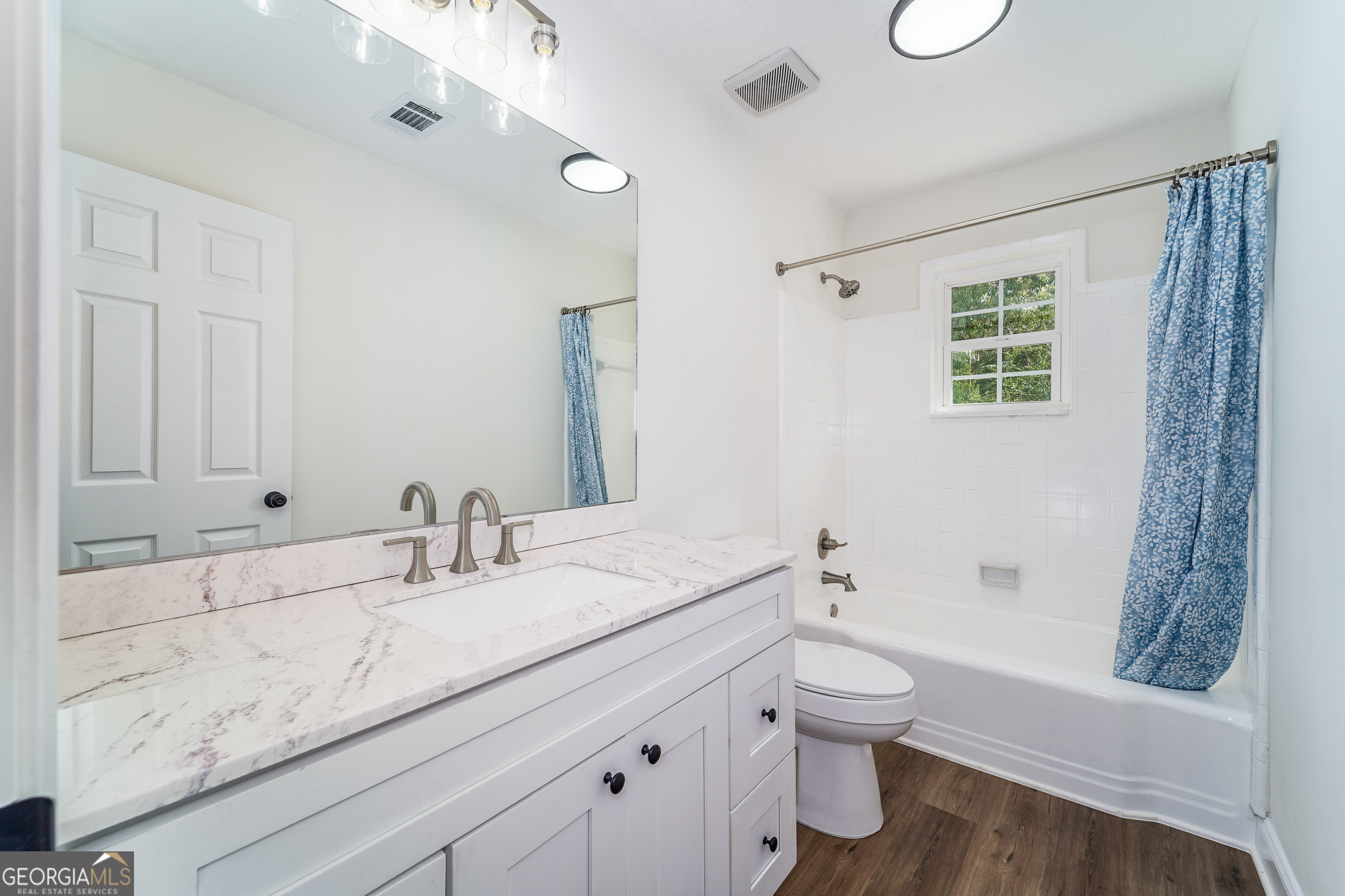 3551 Cason Road Blackshear, GA 31516 - Photo 19 of 24 a bathroom with a granite countertop sink toilet a large mirror a bathtub and shower