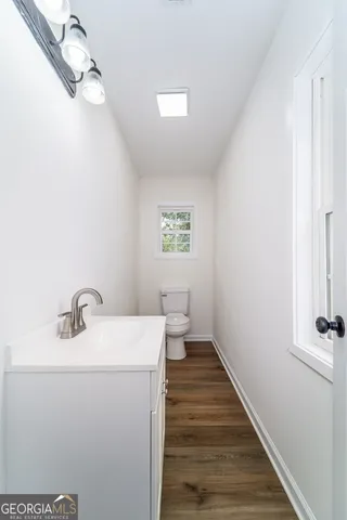 a bathroom with a sink a toilet and a window