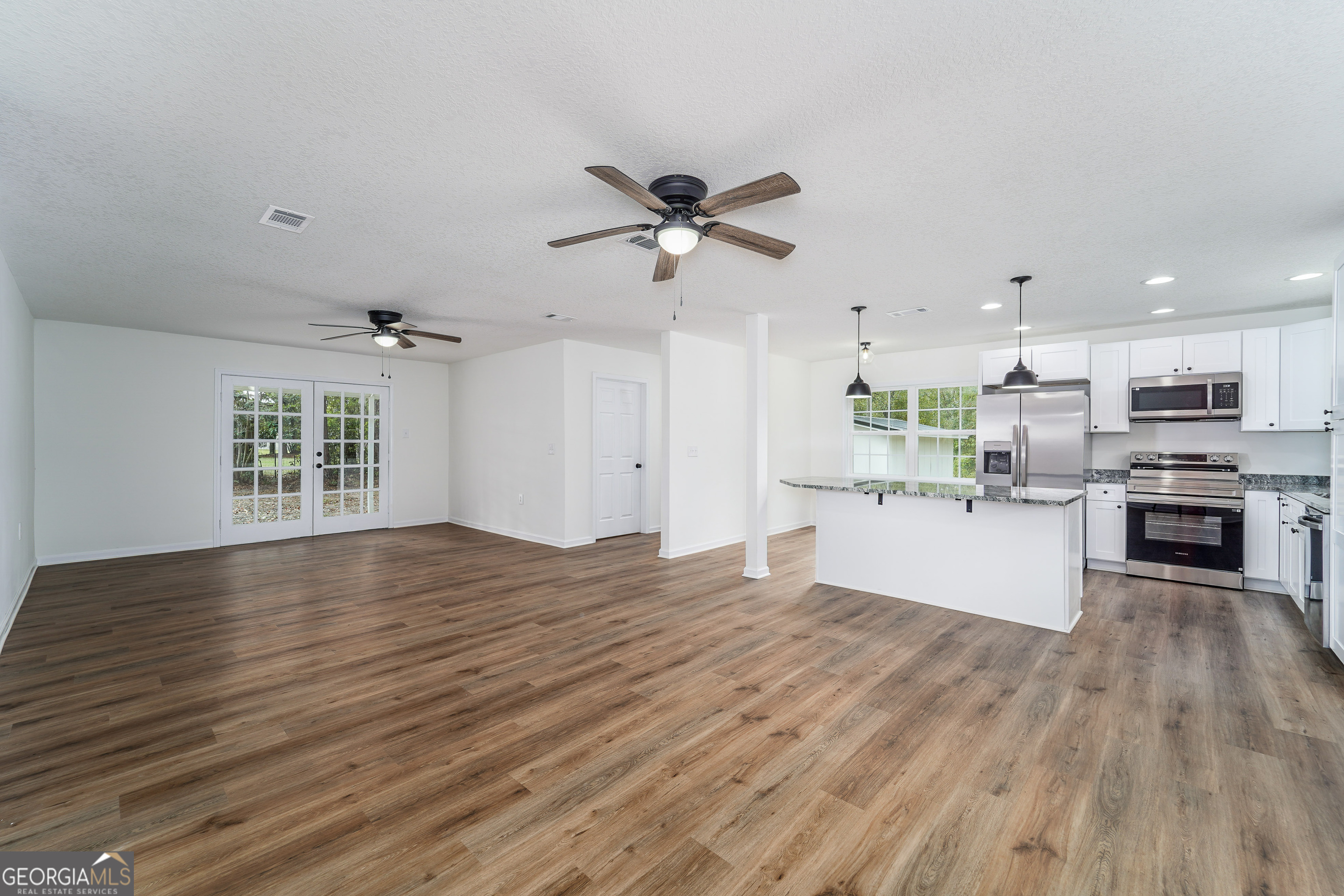 3551 Cason Road Blackshear, GA 31516 - Photo 6 of 24 a view of kitchen and empty room with wooden floor a ceiling fan
