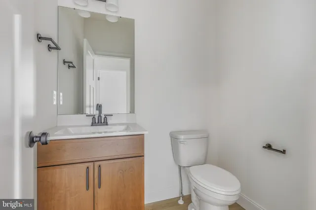 a bathroom with a granite countertop toilet sink and mirror