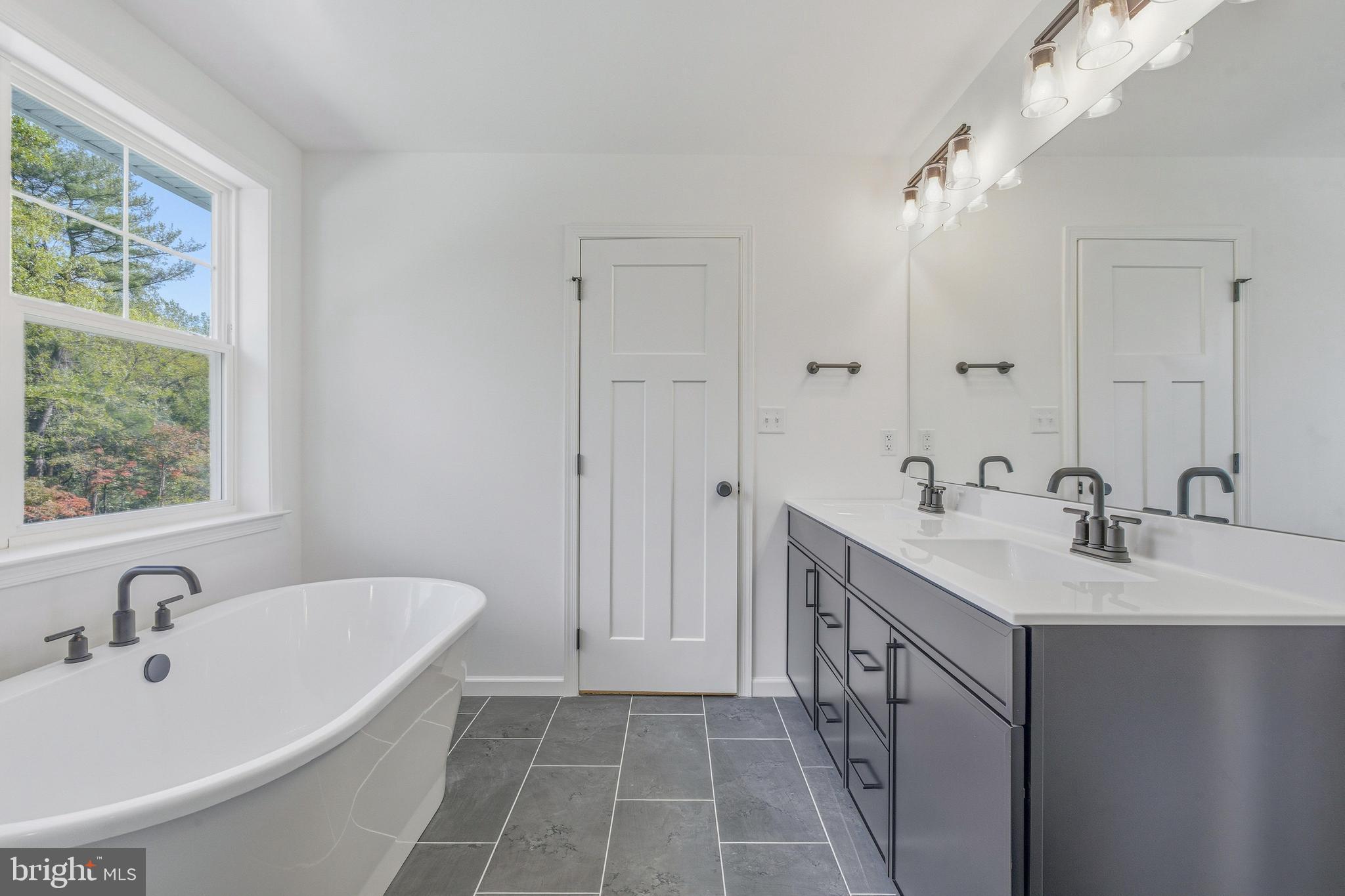 1050 Glen Hall Road Kennett Square, PA 19348 - Photo 26 of 42 a bathroom with a double vanity sink a mirror and a bathtub