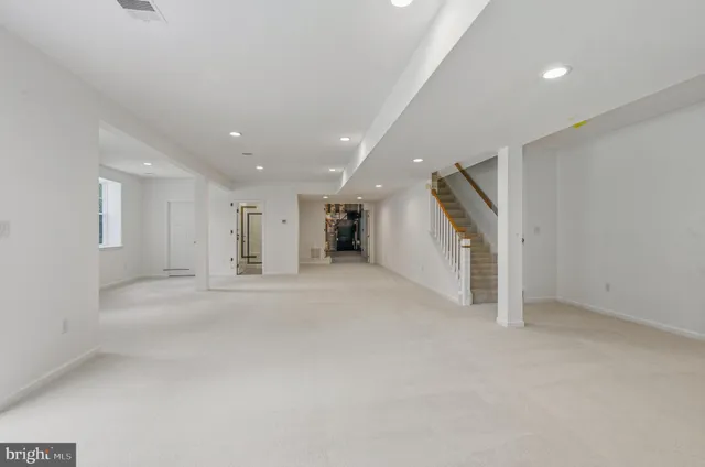 an empty room with a window and a refrigerator