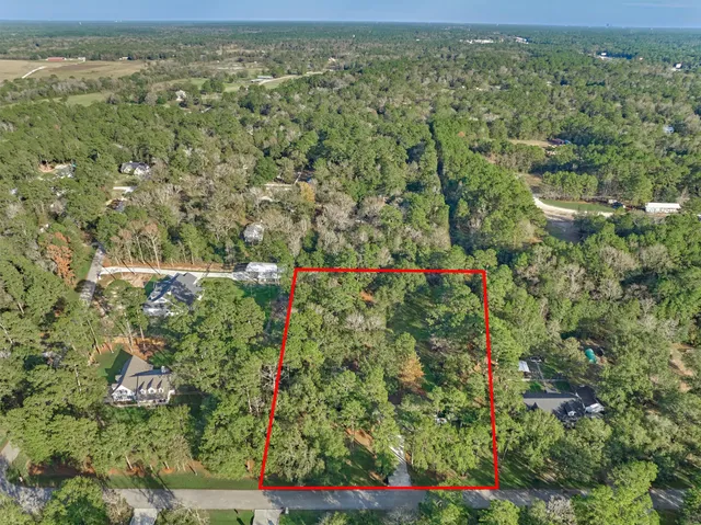 an aerial view of residential houses with outdoor space and trees