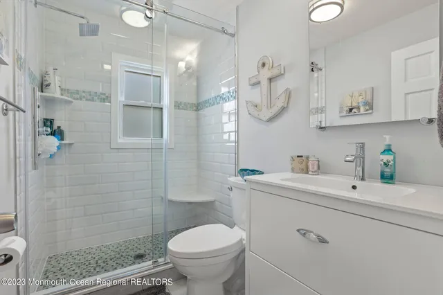 a bathroom with a sink a toilet and shower
