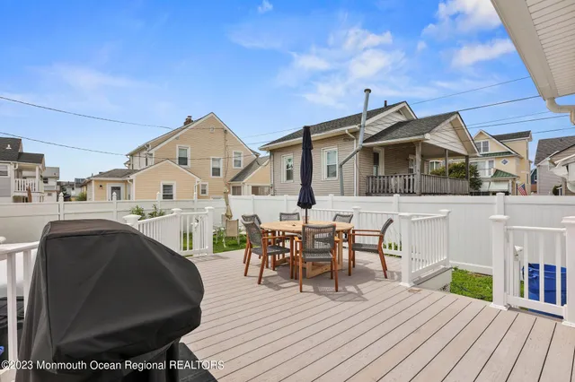 a view of a house with wooden deck and furniture