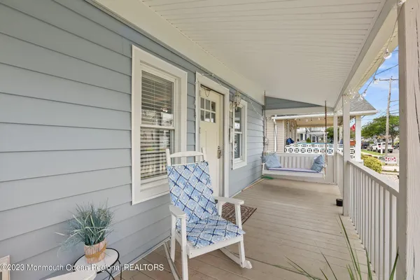 a porch with chairs and potted plant