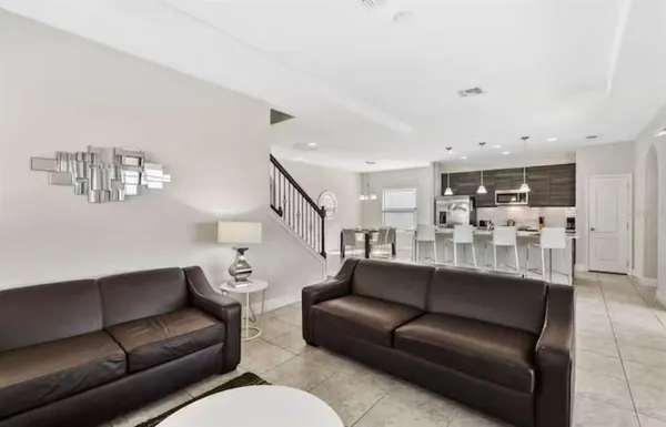 a living room with furniture and kitchen view