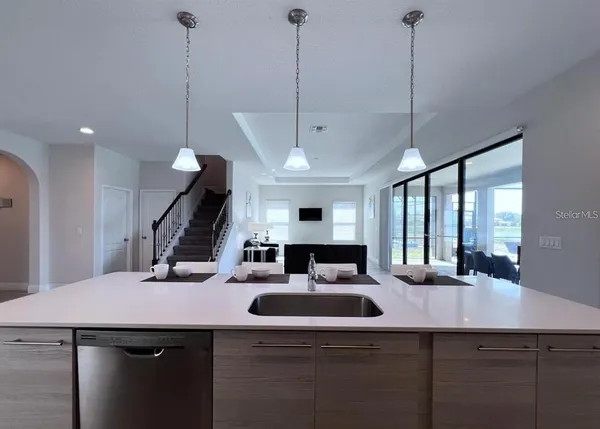 a kitchen with a sink a counter and chairs