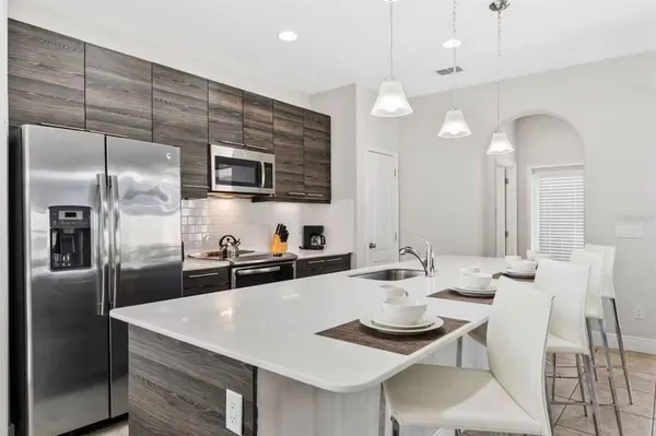 a kitchen with a dining table chairs and refrigerator
