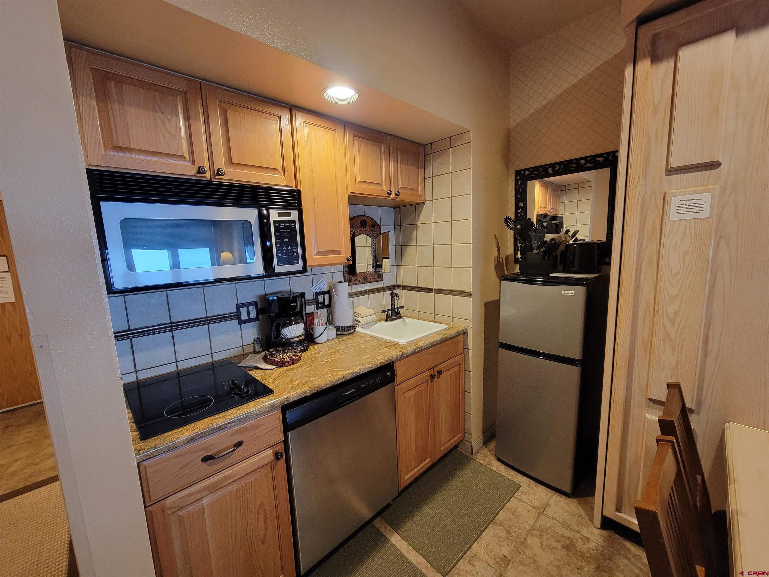 71 Needles Way, Unit 347 Durango, CO 81301 - Photo 5 of 31 a kitchen with a sink a refrigerator and cabinets