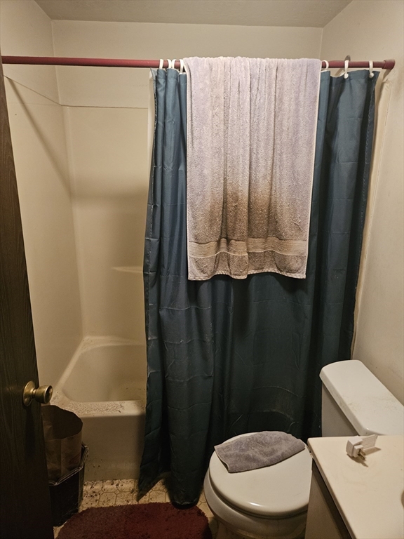 490 School Street, Unit 2 Lowell, MA 01851 - Photo 18 of 26 a bathroom with a toilet a sink and a shower curtain