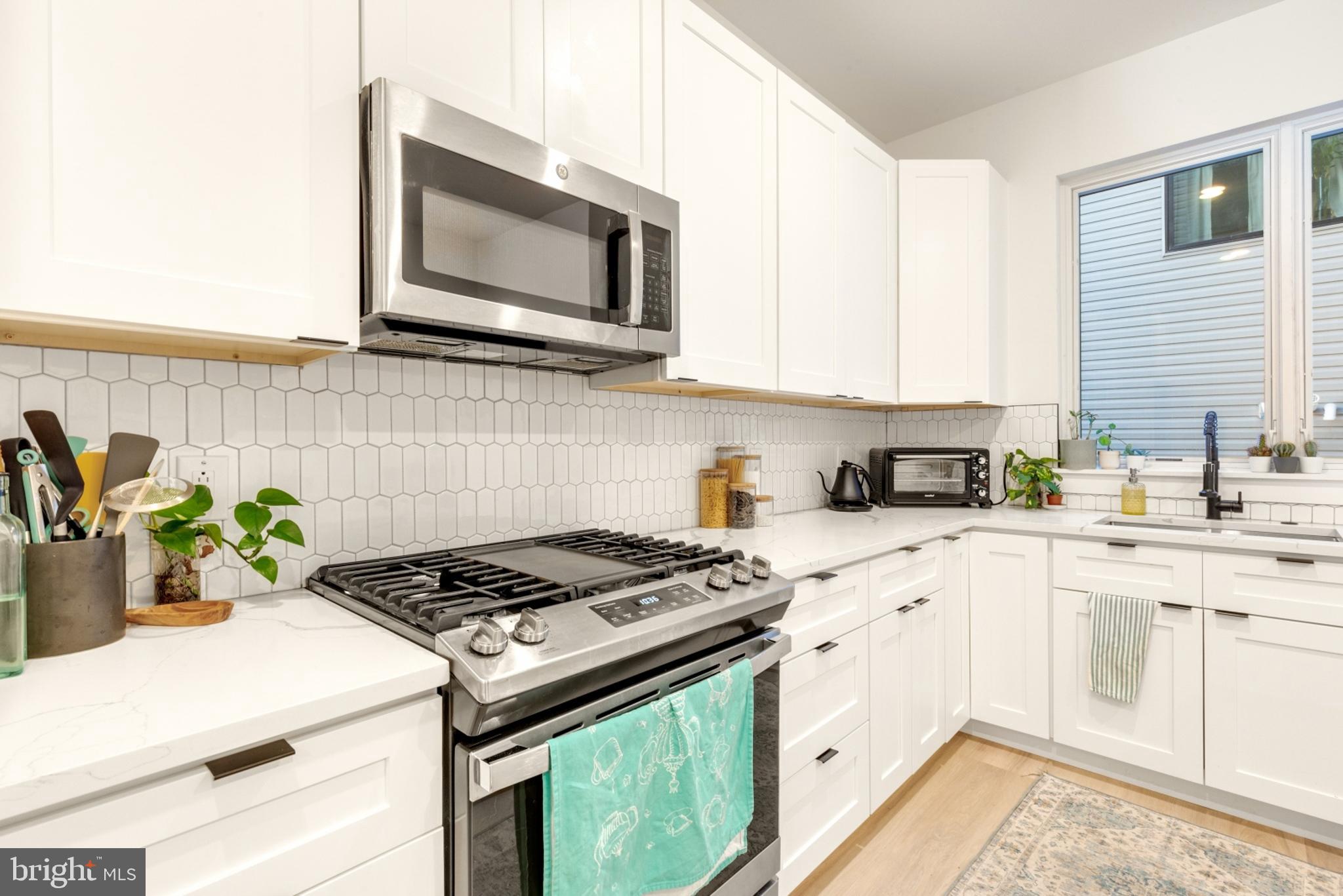 2212 North Front Street, Unit 5 Philadelphia, PA 19133 - Photo 9 of 25 a kitchen with stainless steel appliances white cabinets a stove top oven a sink and dishwasher