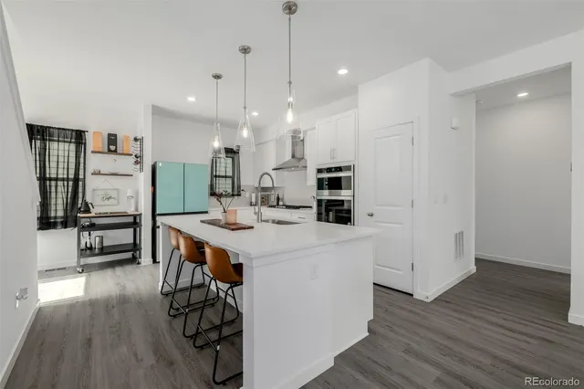 a kitchen with kitchen island a sink a stove a dining table and chairs