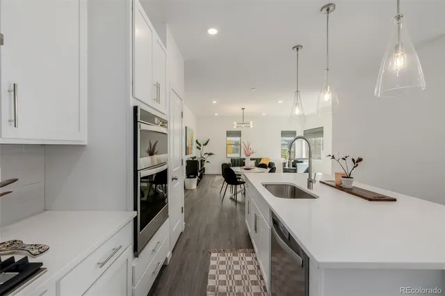 a kitchen with a sink a counter top space appliances and cabinets