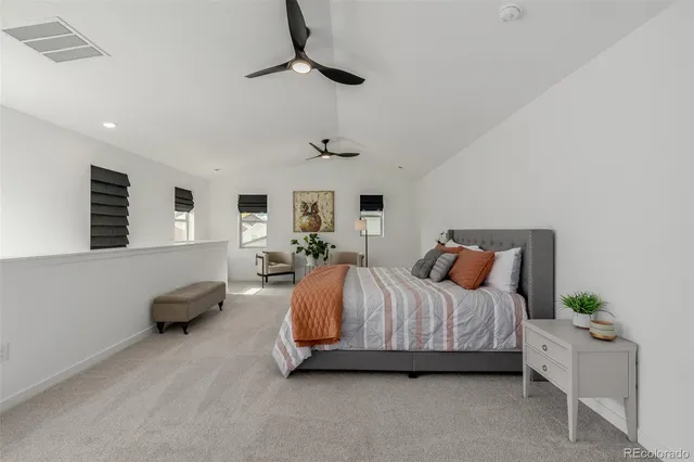 a spacious bedroom with a bed and a chandelier