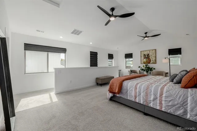 a spacious bedroom with a bed and ceiling fan