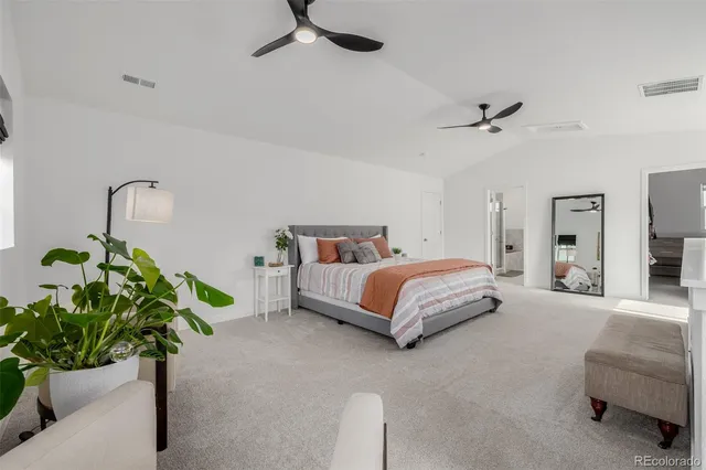 a bedroom with a bed mirror and couch