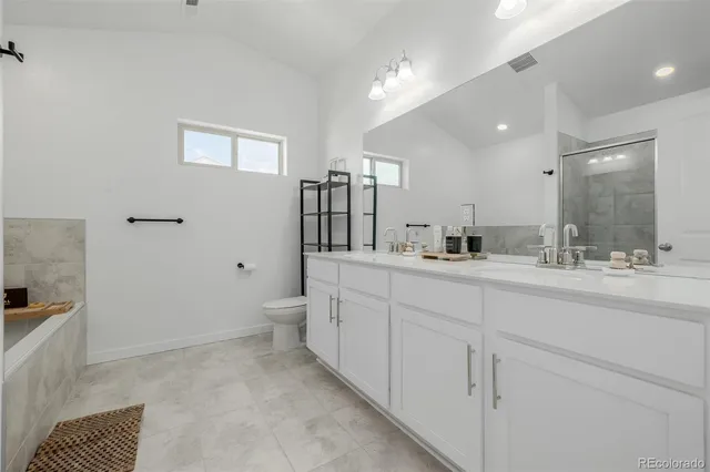 a bathroom with a double vanity sink a toilet and a mirror