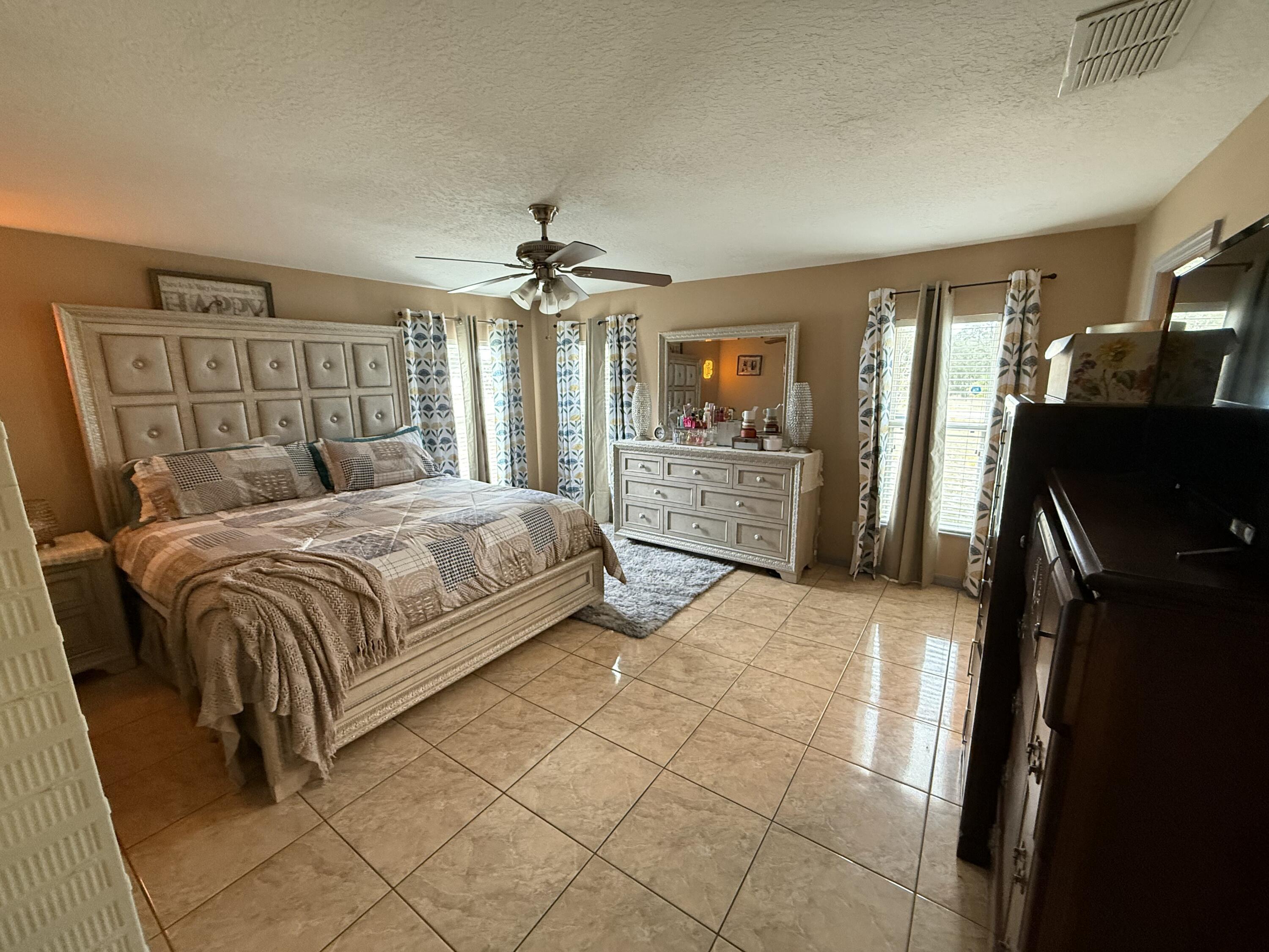 4010 Watkins Road Haines City, FL 33844 - Photo 3 of 8 a bedroom with a bed dresser and a flat tv screen