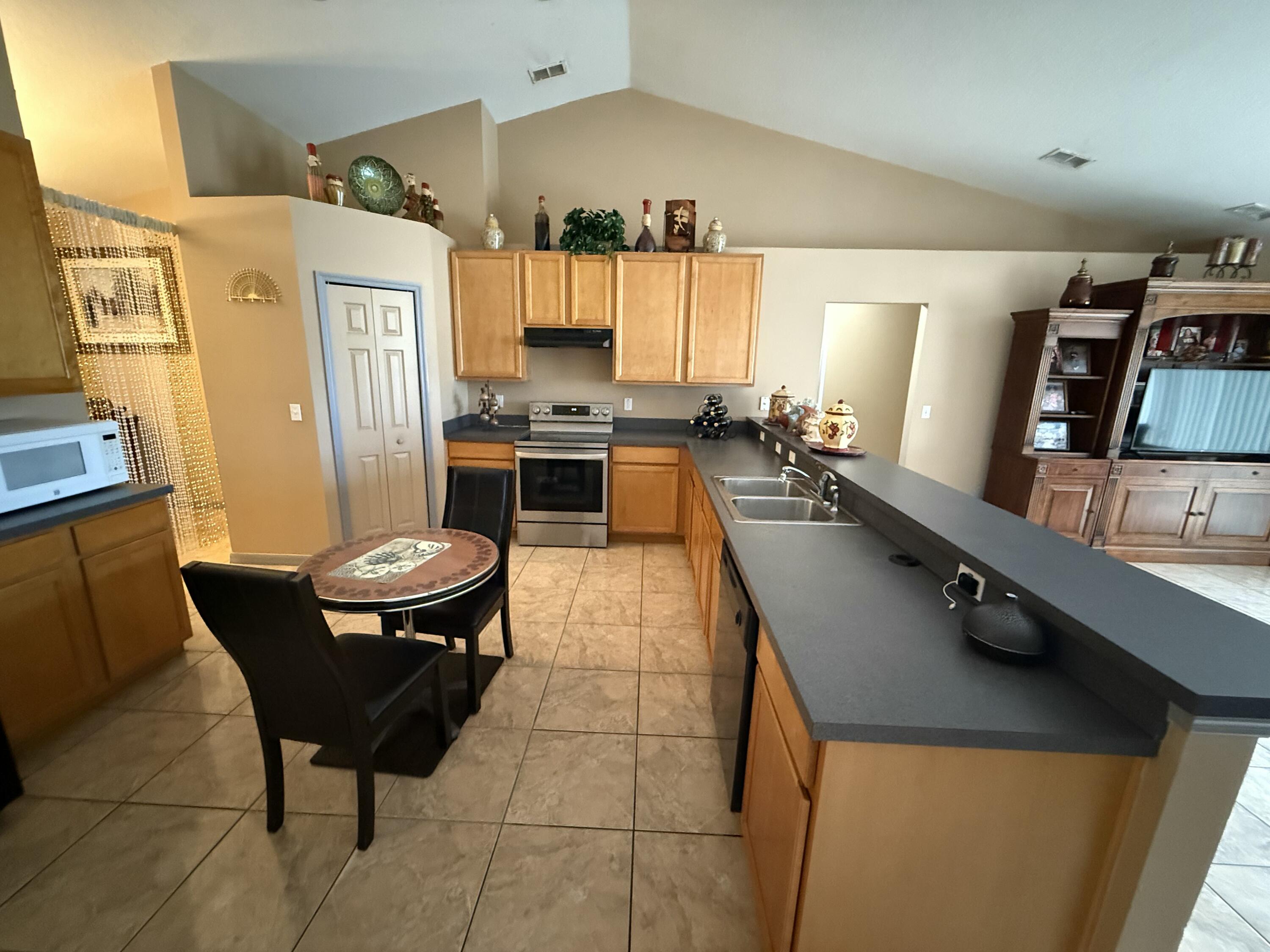 4010 Watkins Road Haines City, FL 33844 - Photo 6 of 8 a kitchen with stainless steel appliances a sink a stove a refrigerator a dining table and chairs with wooden floor
