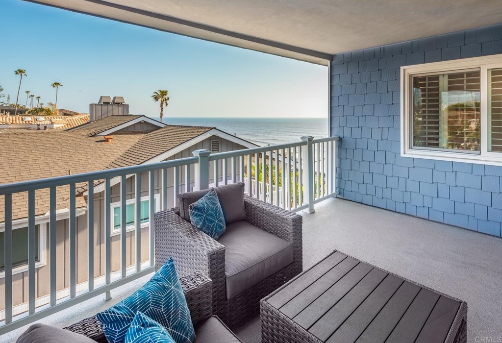 510 4th Street, Unit 3C Encinitas, CA 92024 - Photo 23 of 30 a balcony with two couches and a dining table with wooden floor