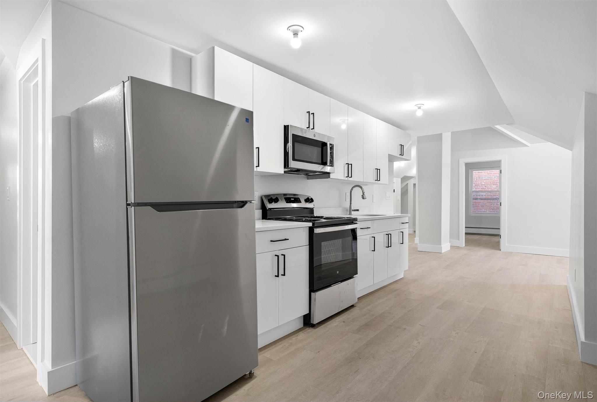 a kitchen with stainless steel appliances a refrigerator a stove a microwave and cabinets