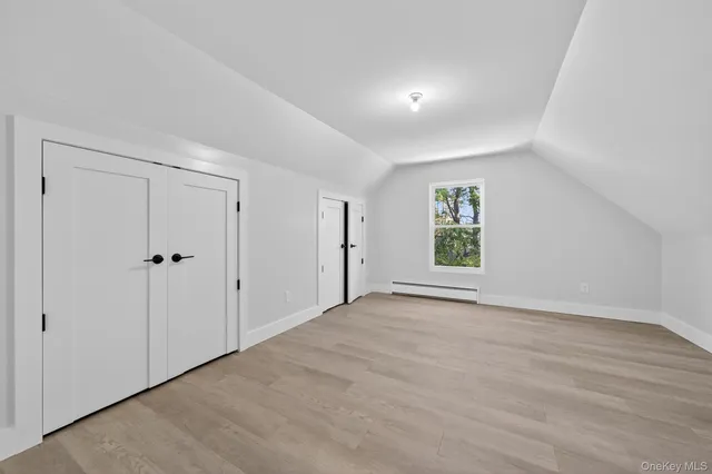 an empty room with wooden floor and door