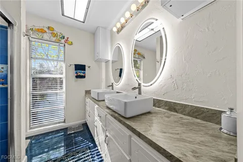 a en suite bathroom with a granite countertop sink and a mirror