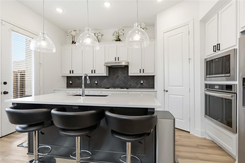 1128 Queensdown Way Forney, TX 75126 - Photo 11 of 25 a kitchen with cabinets a sink and appliances