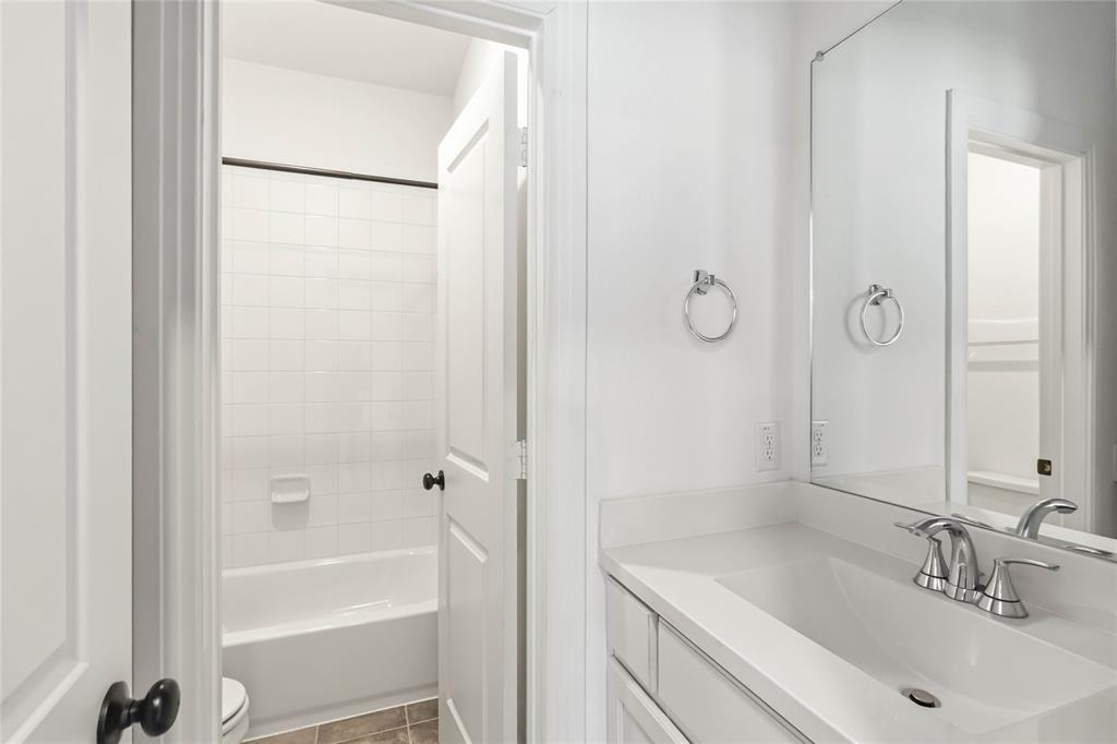 1128 Queensdown Way Forney, TX 75126 - Photo 19 of 25 a bathroom with a tub shower vanity and a sink