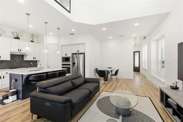 a living room with stainless steel appliances kitchen island granite countertop a couch and cabinets