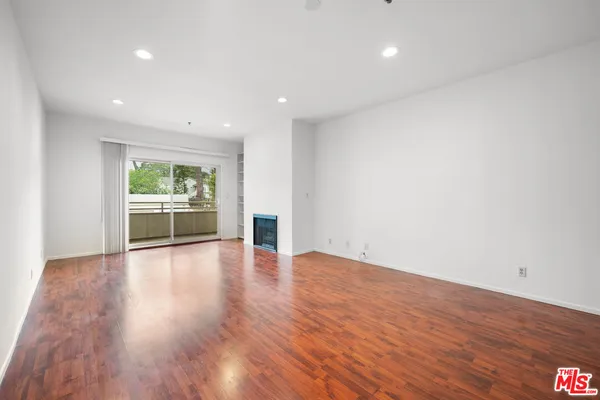a view of empty room with wooden floor and windows