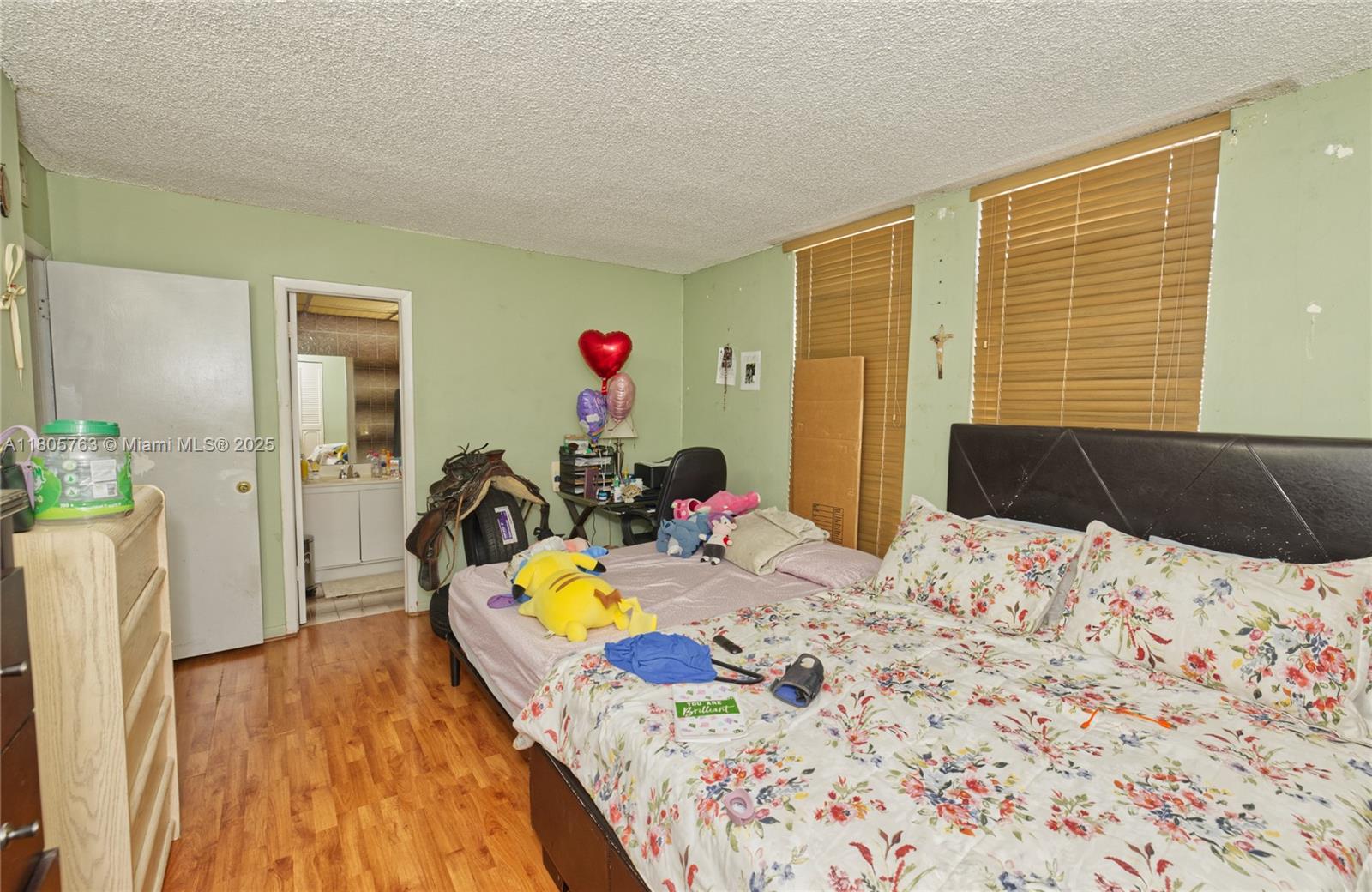 1750 West 46th Street, Unit 503 Hialeah, FL 33012 - Photo 13 of 24 a bed room with a bed and a wooden floor