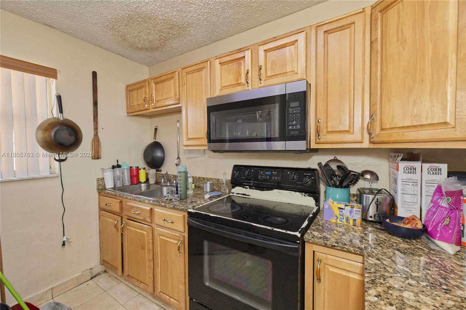 1750 West 46th Street, Unit 503 Hialeah, FL 33012 - Photo 10 of 24 a kitchen with stainless steel appliances granite countertop a sink stove and cabinets