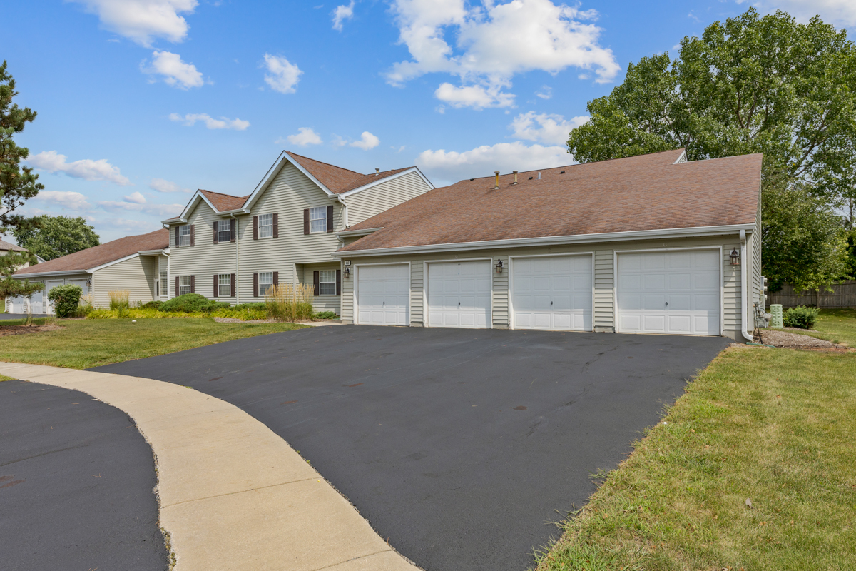 86 Gant Circle, Unit D Streamwood, IL 60107 - Photo 14 of 16 a front view of a house with a garden and yard