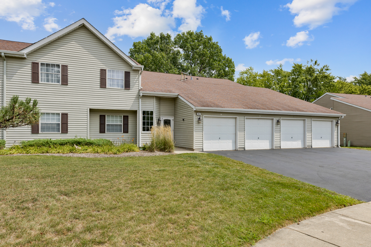 86 Gant Circle, Unit D Streamwood, IL 60107 - Photo 16 of 16 a front view of a house with a yard and garage