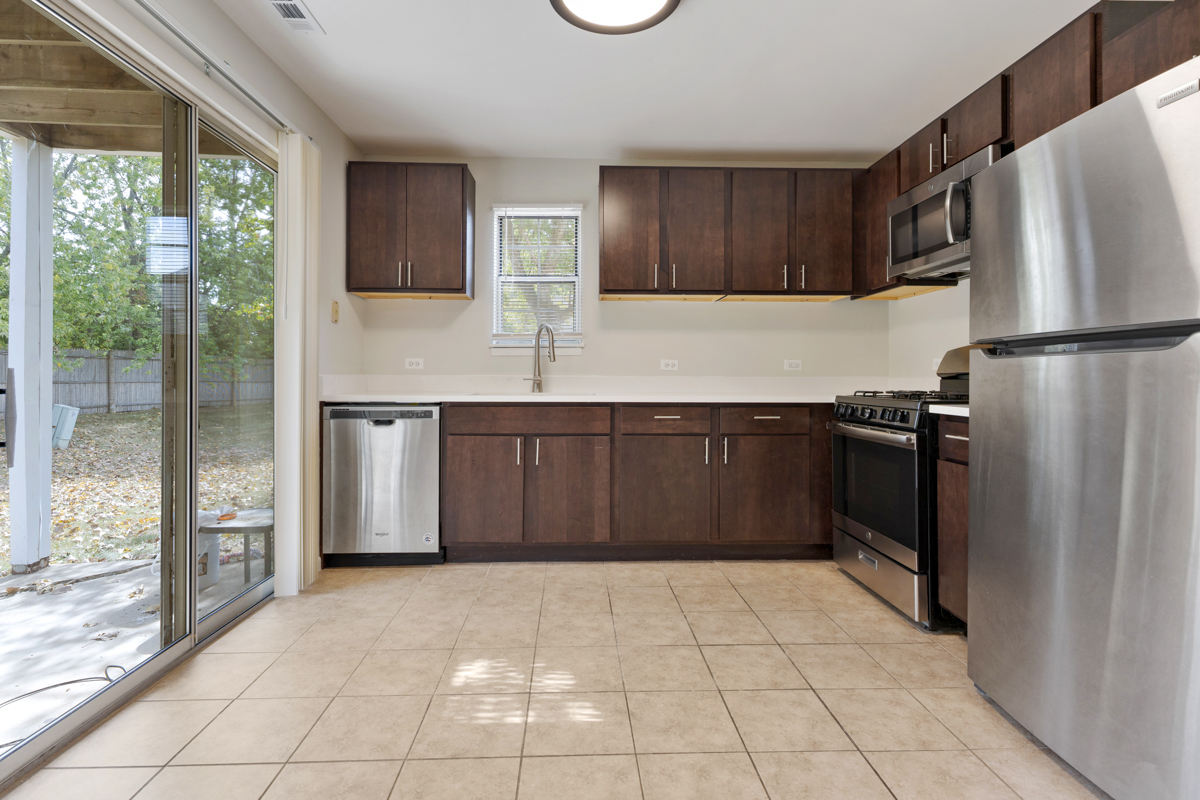 86 Gant Circle, Unit D Streamwood, IL 60107 - Photo 5 of 16 a kitchen with stainless steel appliances granite countertop a refrigerator and a sink