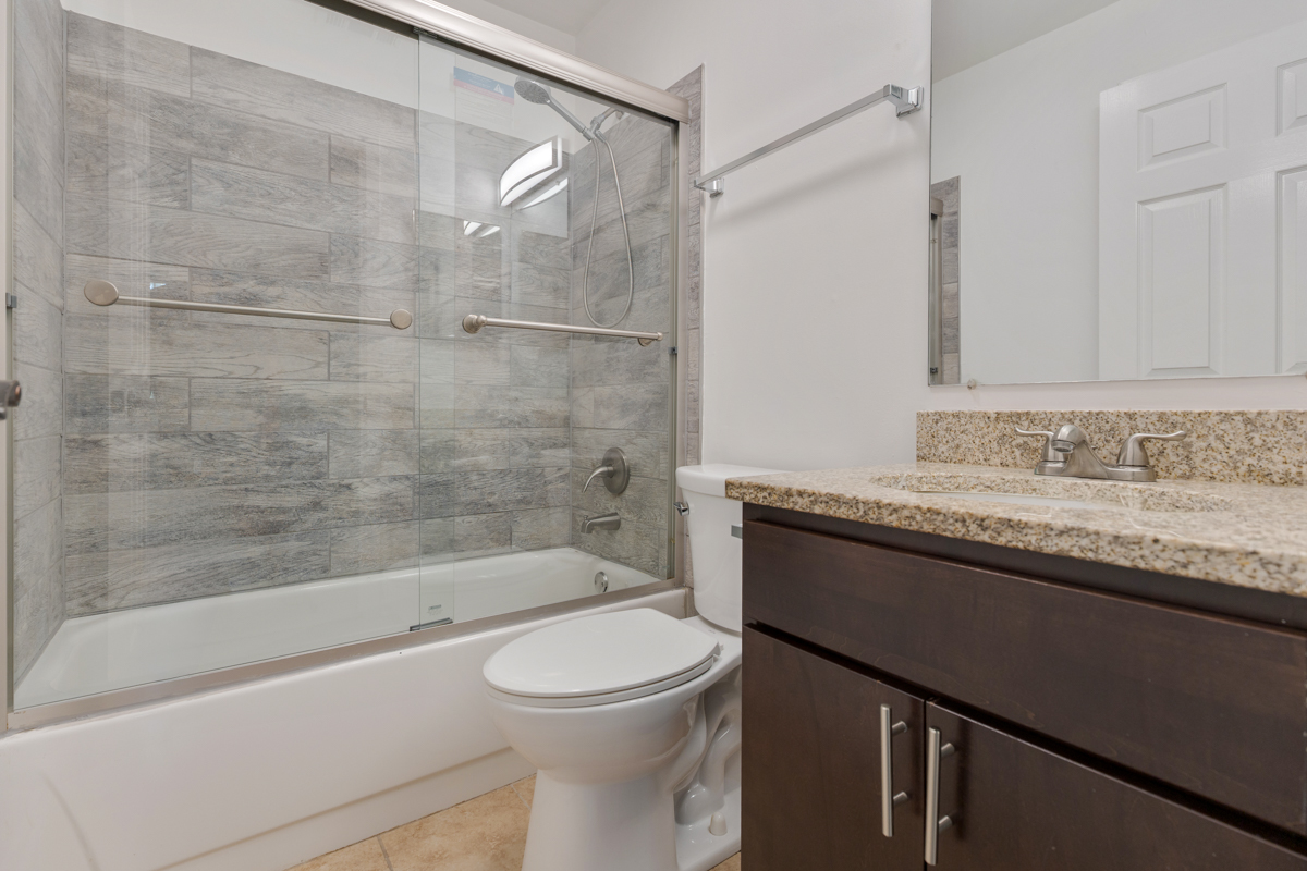 86 Gant Circle, Unit D Streamwood, IL 60107 - Photo 8 of 16 a bathroom with a granite countertop sink a toilet and bathtub