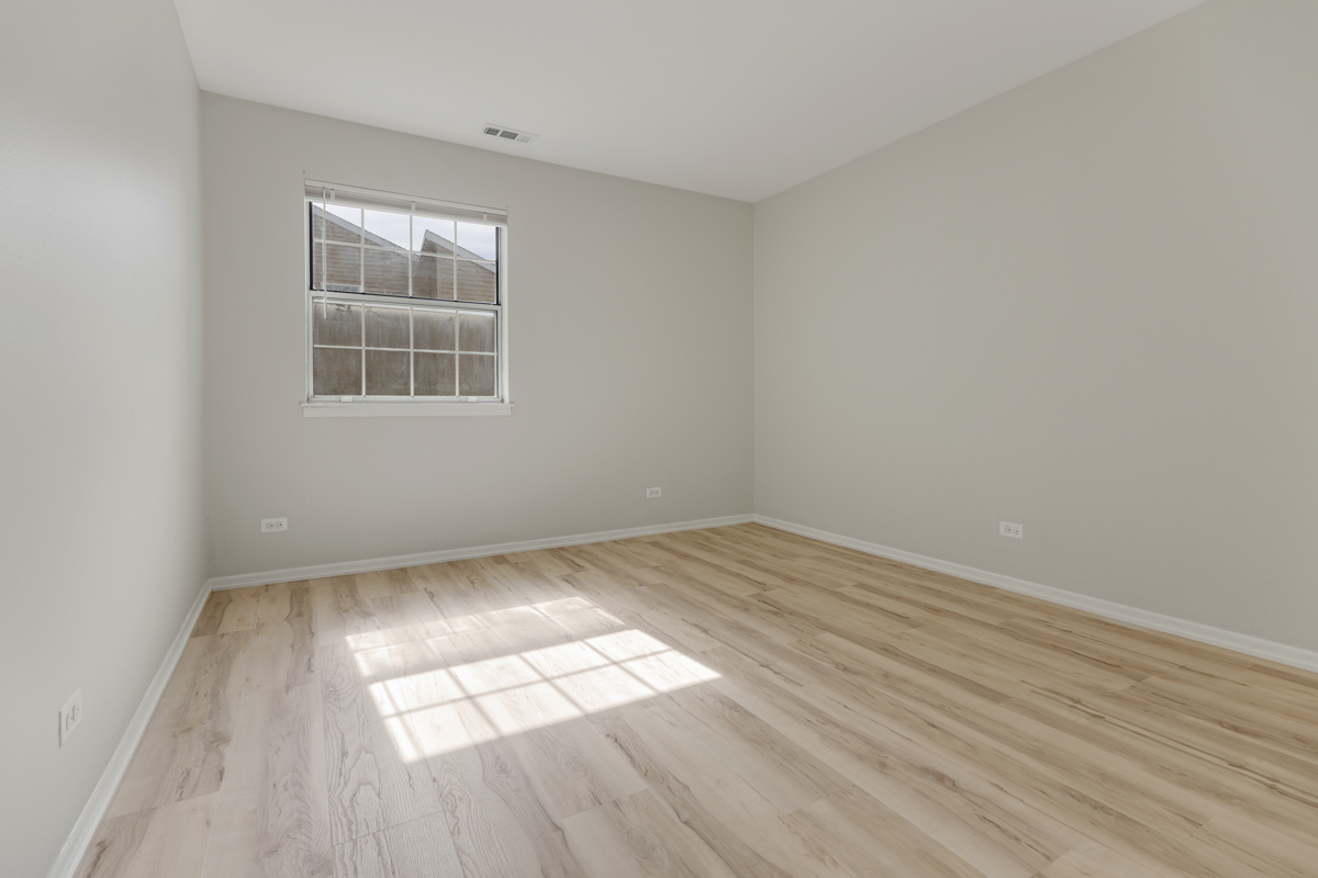 86 Gant Circle, Unit D Streamwood, IL 60107 - Photo 9 of 16 an empty room with wooden floor and windows