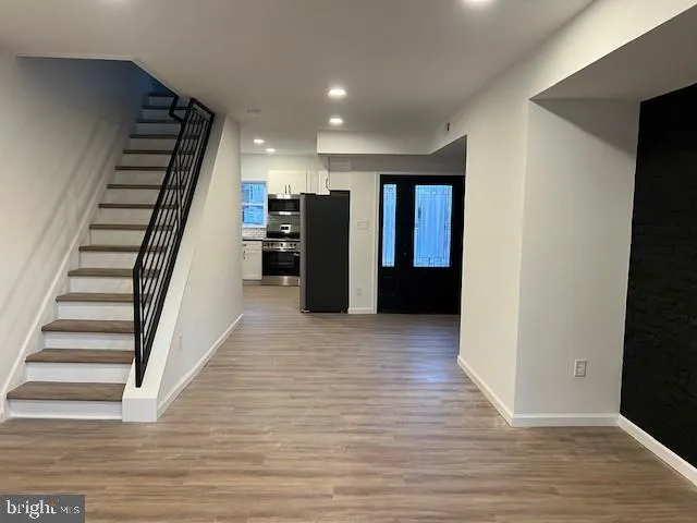 a view of a hallway with wooden floor and stairs