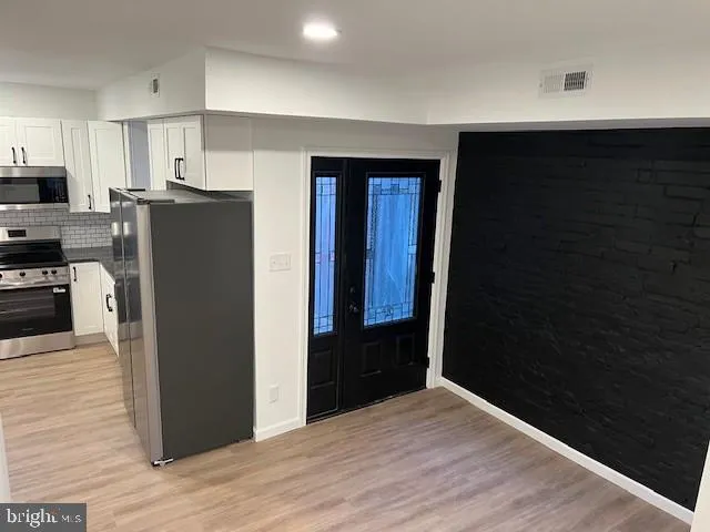 a kitchen with a refrigerator and cabinets