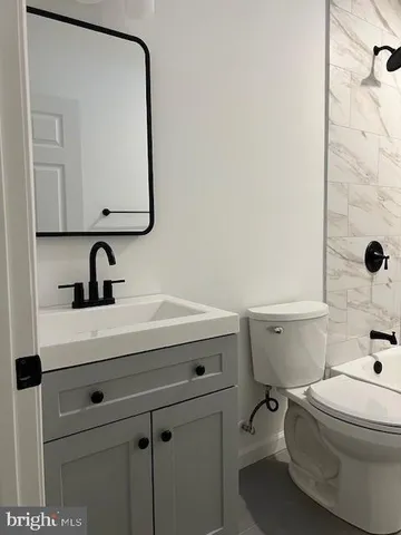 a bathroom with a sink vanity mirror and toilet