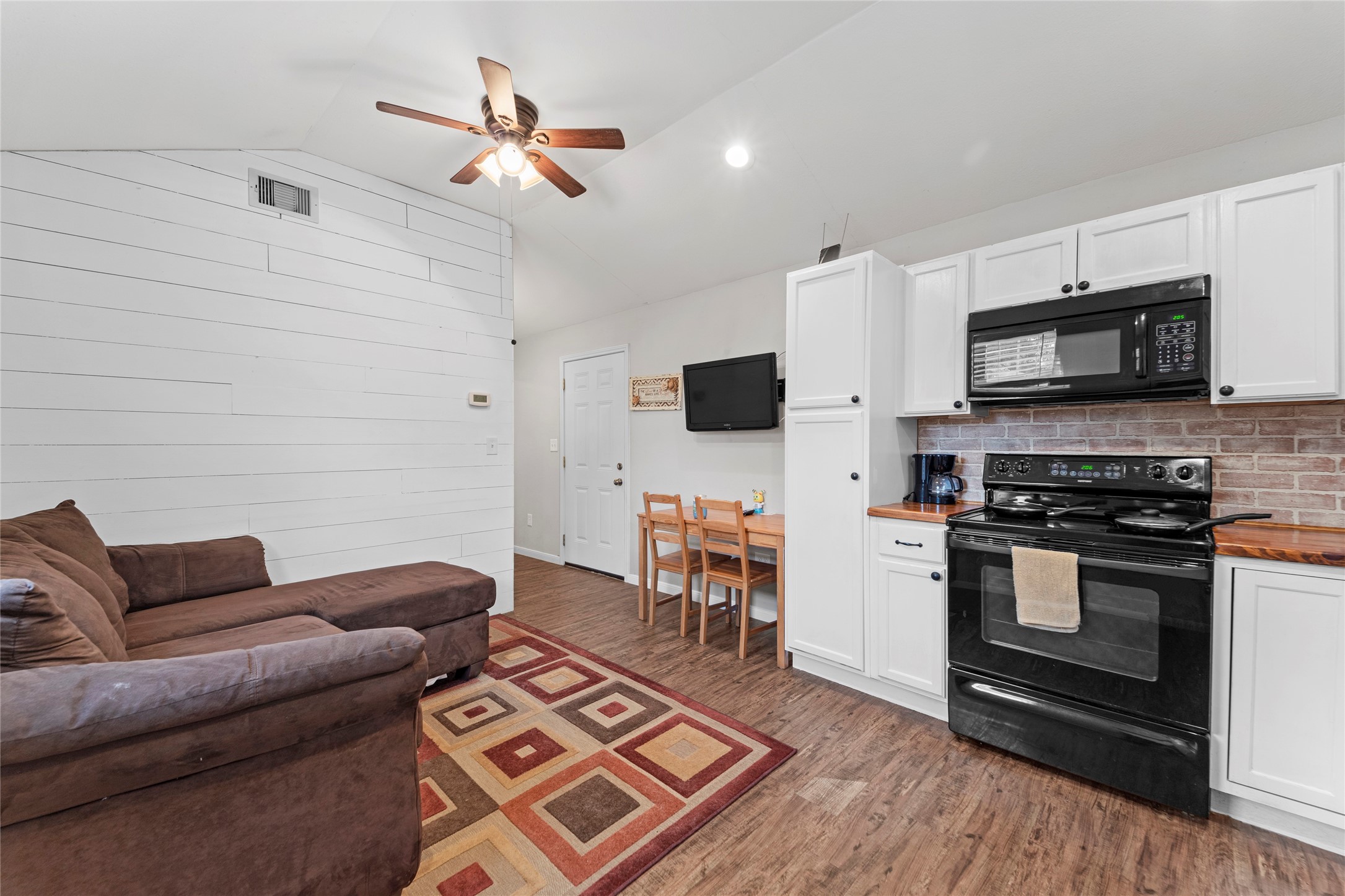 6951 Leandra Drive Houston, TX 77083 - Photo 2 of 12 a living room with furniture a flat screen tv and kitchen view