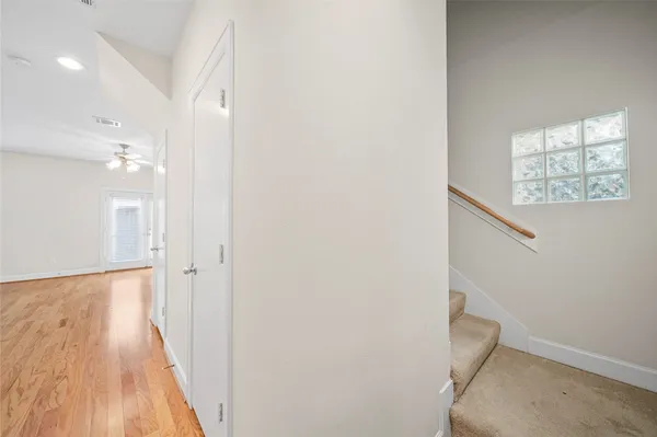 a view of a hallway with wooden floor and staircase
