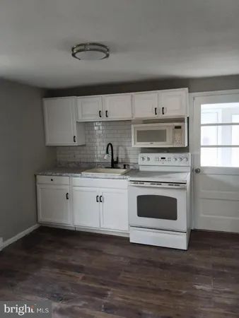 a kitchen with cabinets wooden floor and a sink