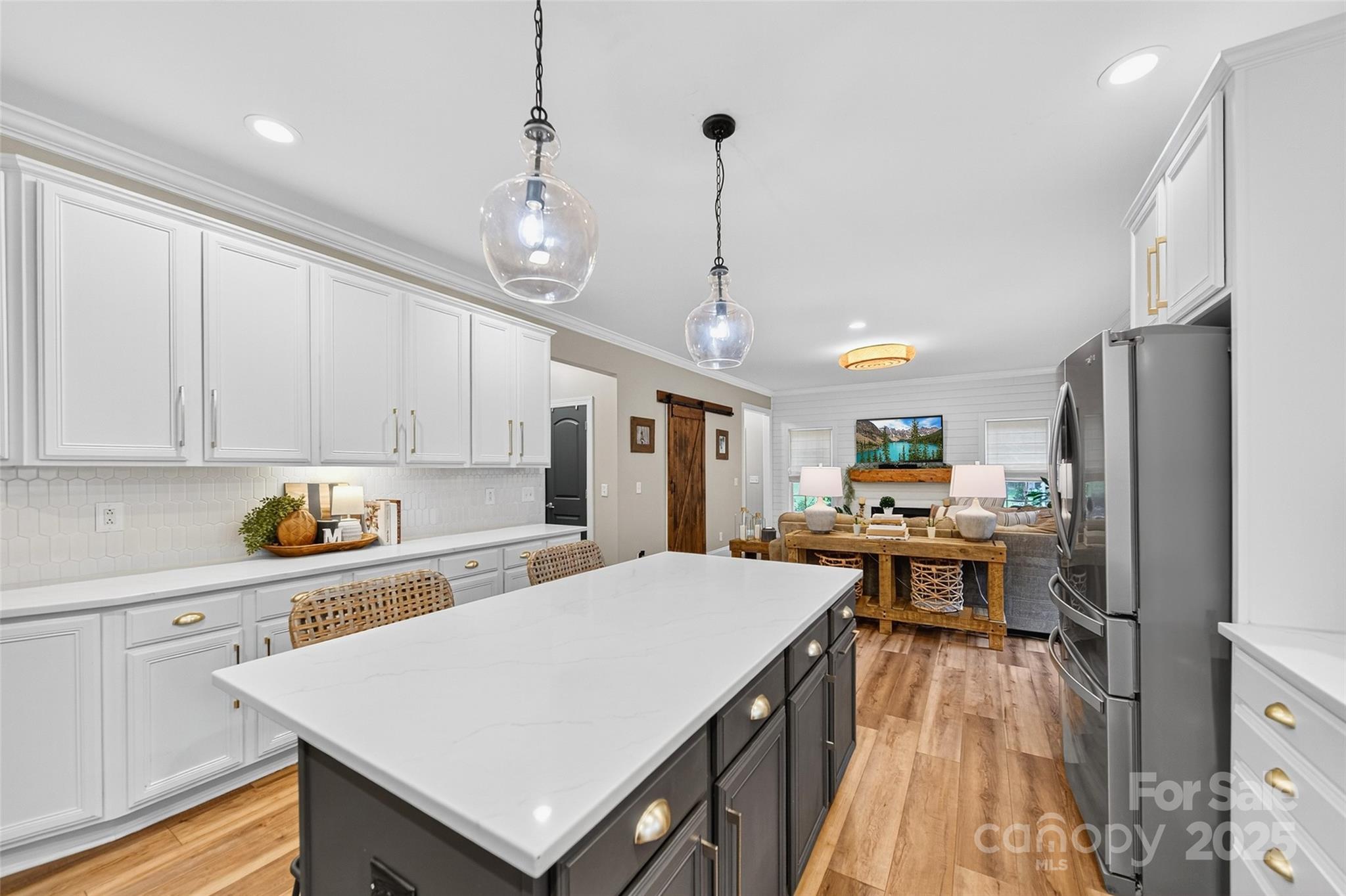 3575 Gordon Street Terrell, NC 28682 - Photo 27 of 48 a kitchen with stainless steel appliances a stove a refrigerator a sink dishwasher and white cabinets with wooden floor