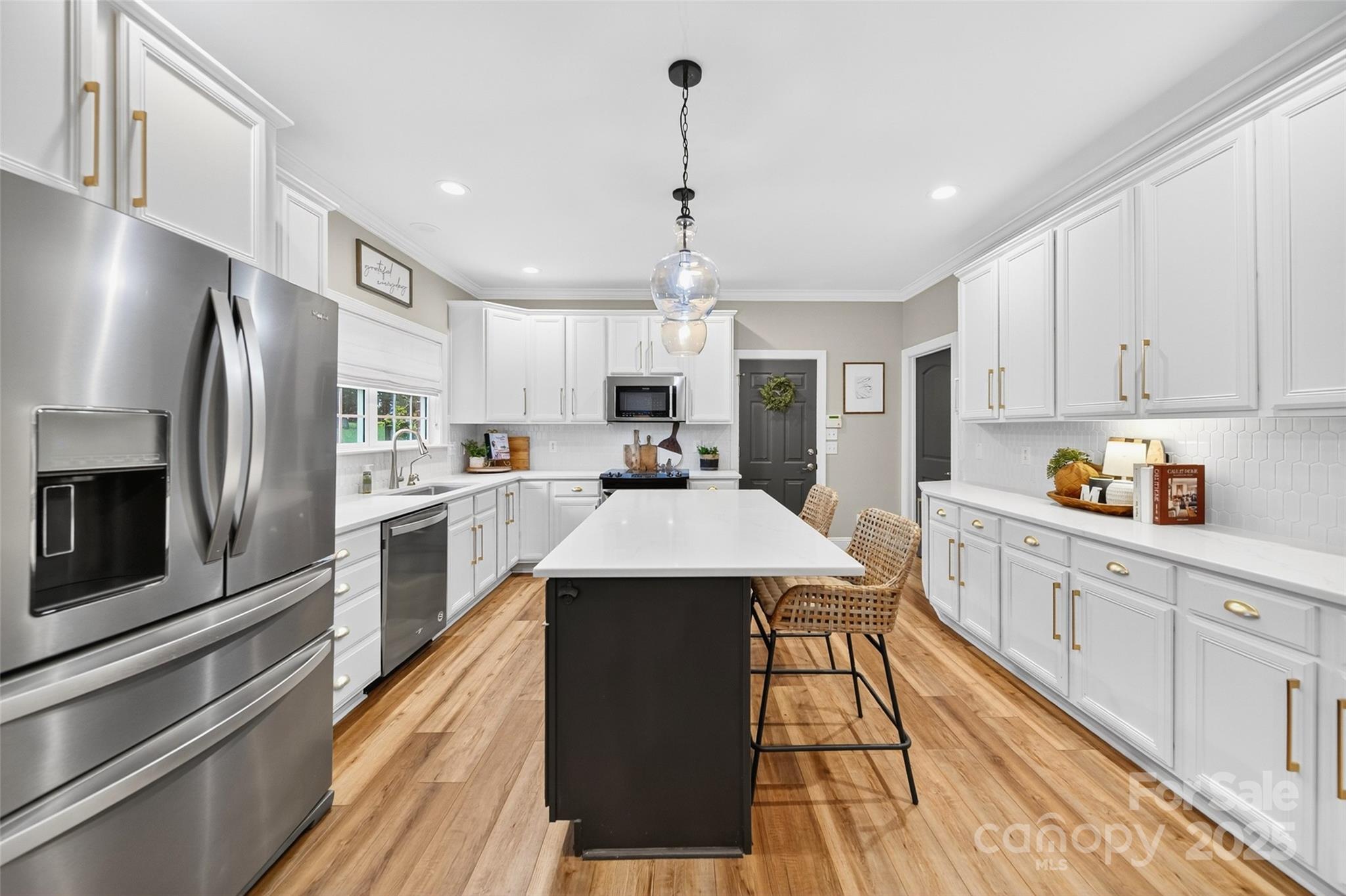 3575 Gordon Street Terrell, NC 28682 - Photo 28 of 48 a kitchen with stainless steel appliances kitchen island granite countertop a refrigerator a sink dishwasher a stove and white cabinets with wooden floor