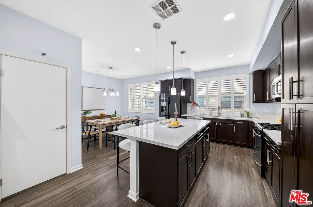 676 Colorado Circle Carson, CA 90745 - Photo 11 of 36 a kitchen with kitchen island granite countertop a sink appliances and wooden floor